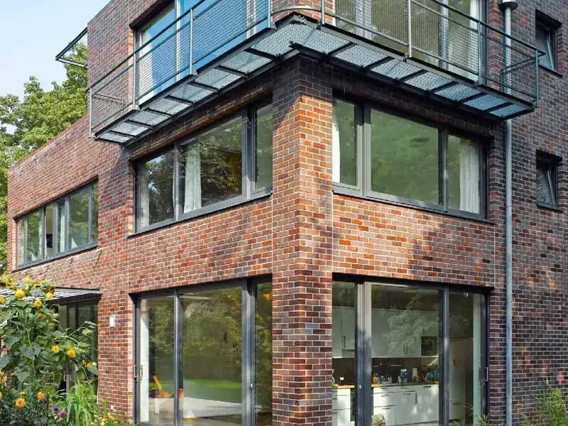 Brick townhouse with full-height Schueco CT 70 uPVC glazing and glass balustrades