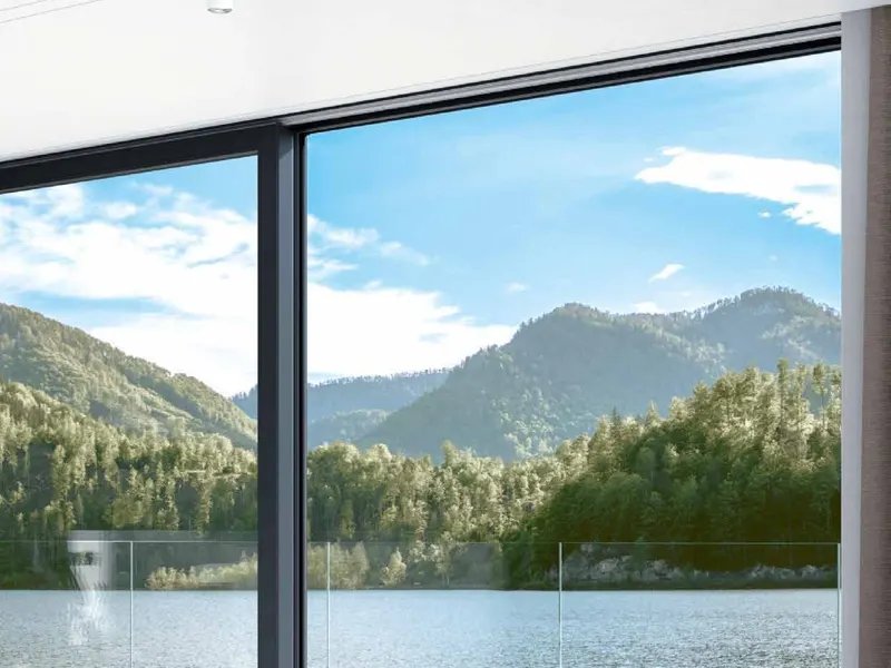 Schueco LivIngSlide lift and slide door opening to a lake view