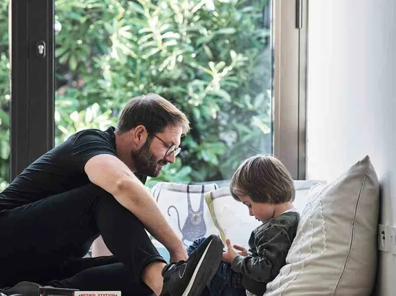 Father and son sitting by a floor-to-ceiling uPVC sliding door