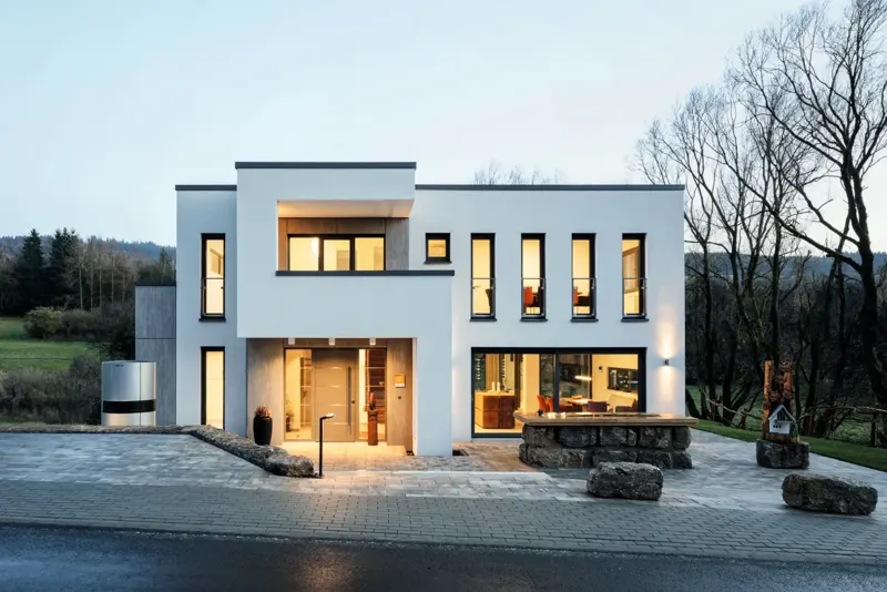 Modern white house with dark Schueco uPVC windows at dusk