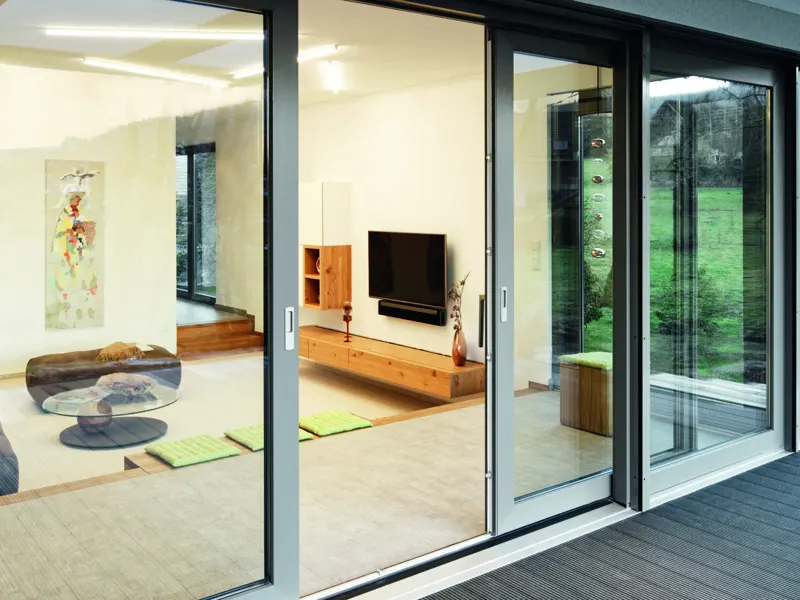 Three-panel uPVC sliding door seen from a terrace into a modern living room