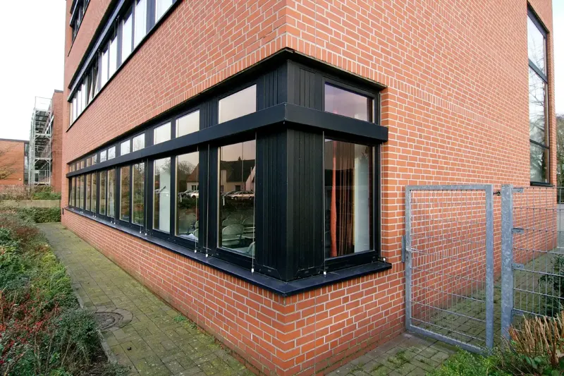 Brick building with a long run of black uPVC windows